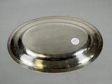 a silver plate on a white surface with a sticker on it