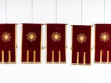 three red and gold flags hanging from the ceiling of a room