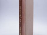 an old book with a brown cover sitting on top of a white surface