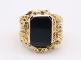 an image of a gold ring with a black stone in it