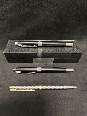 three different types of pens and a box on a table