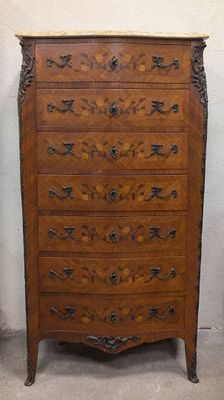 a wooden chest of drawers with a marble top