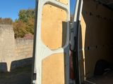 une camionnette blanche dont la portière est ouverte, garée sur le bord de la route