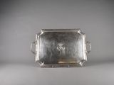 an antique silver tray with handles and handles on a table