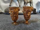 two vases sitting on a table with a horse statue in the background