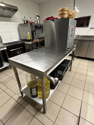 a large stainless steel table in the middle of a kitchen