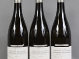 trois bouteilles de vin sont alignées sur une table