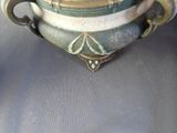 a green and white vase sitting on a table