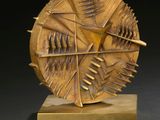 an image of a sculpture of a circular object on a wooden base