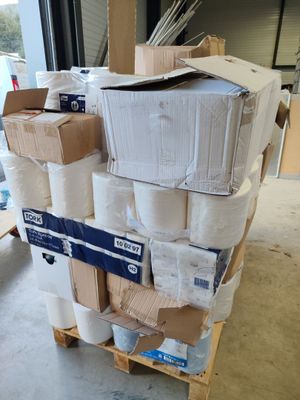 de nombreux rouleaux de papier toilette sur une palette dans un entrepôt