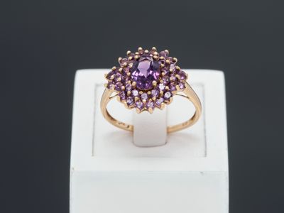 a close up of a ring with a purple stone in it