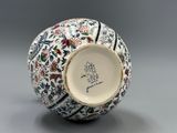 un vase blanc orné d'un motif bleu et rouge