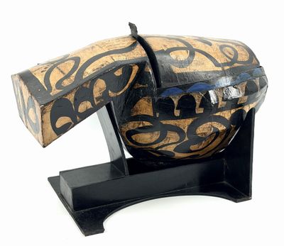 a wooden object with a black and gold design on it