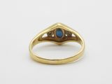 a close up of a gold ring with a blue stone