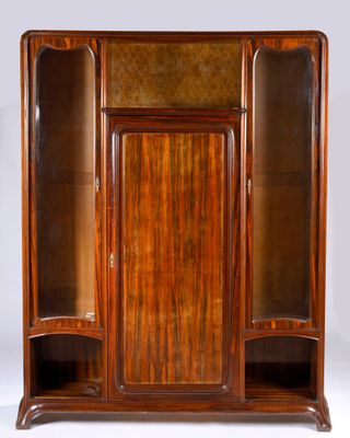 une armoire ancienne en bois avec des portes vitrées et des étagères