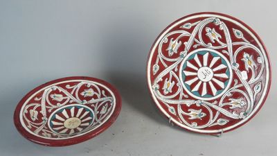 deux bols rouges et blancs ornés de motifs, posés l'un à côté de l'autre
