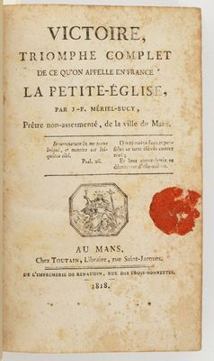 un vieux livre portant un tampon rouge, posé sur une table