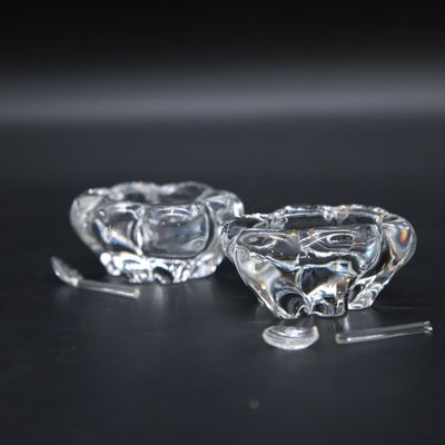pair of clear glass candlestick holders on a black surface