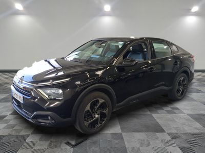 la voiture noire est garée dans le garage sur un sol en damier
