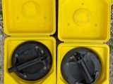 deux récipients en plastique jaunes munis d'un couvercle noir et d'une poignée noire