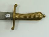 a gold sword with a tag on it on a white surface