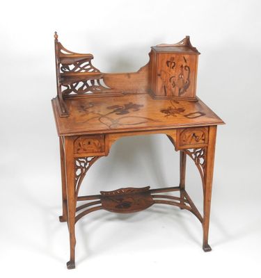 an image of a wooden desk with a carved top and drawers