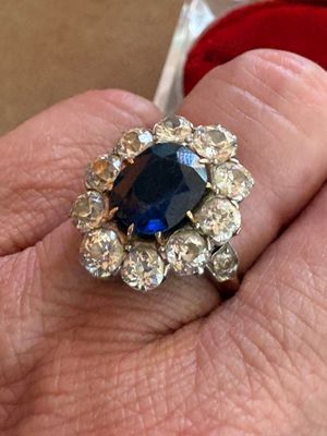 une personne tenant une bague sertie d'une pierre bleue
