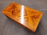 a wooden coffee table with a glass top on a carpeted floor