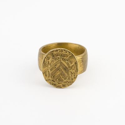 gros plan d'une bague en or sur une surface blanche