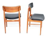 pair of mid - century danish teak dining chairs with black vinyl upholstered seats