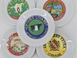 four white plates with different logos on them sitting on a table