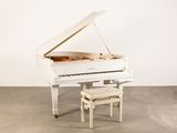 un piano blanc et un tabouret dans une pièce