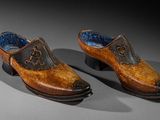 pair of wooden shoes with blue linings on a gray surface
