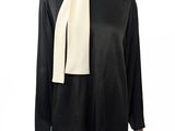 un haut noir et blanc avec un foulard blanc sur un mannequin