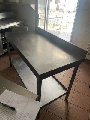 une table dans la cuisine, avec une feuille de papier posée à côté