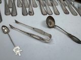 a lot of silver spoons and forks on the table