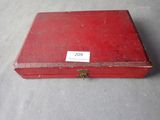 an old red box with a label on it sitting on a table