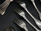 a lot of silver spoons and forks on a table