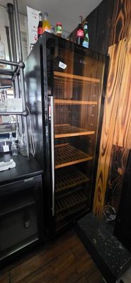 a black refrigerator with a glass door in a kitchen