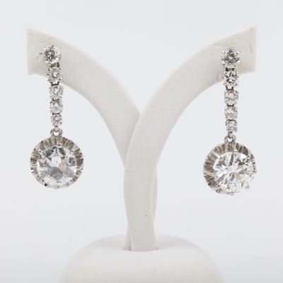 an image of a pair of diamond earrings on a stand