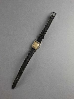 a close up of a watch on a gray surface with a black strap