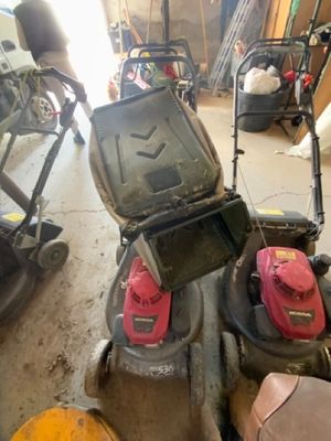 deux tondeuses à gazon et une tondeuse à gazon dans un garage