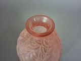 a pink glass vase with a lacy design on it