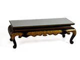 une table basse noire et dorée avec un plateau en verre