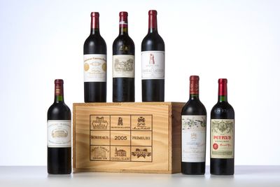 several bottles of wine sit in front of a wooden box