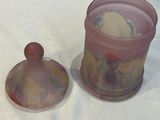 a glass jar with a lid sitting next to a glass container