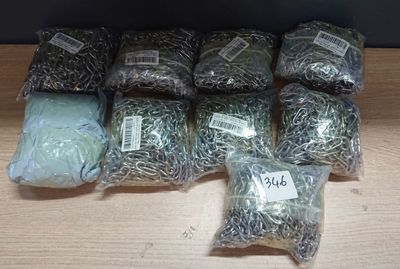 plusieurs sacs d'herbe posés sur une table, avec des étiquettes dessus