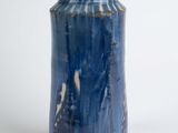 a blue vase that is sitting on a white surface