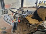 un tracteur qui est à l'arrêt dans la boue à l'intérieur d'un bâtiment