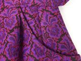 a close up of a purple and black paisley print fabric
